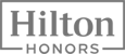 The image shows the logo for Hilton Honors, a loyalty program by Hilton hotels, with "Hilton" in large text and "Honors" underneath in smaller text.