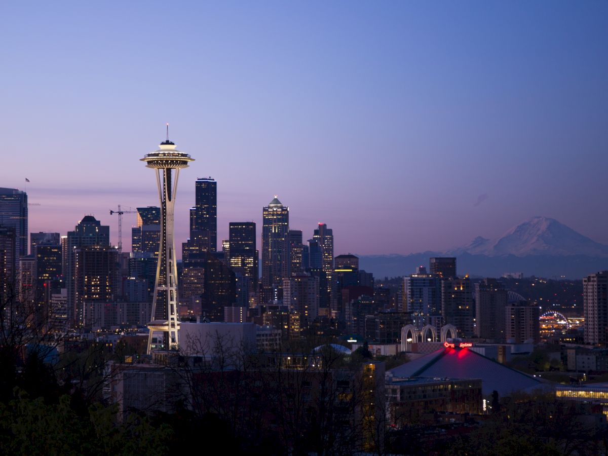 City skyline at dawn with the iconic Space Needle and Mount Rainier in the background, Seattle, Washington.